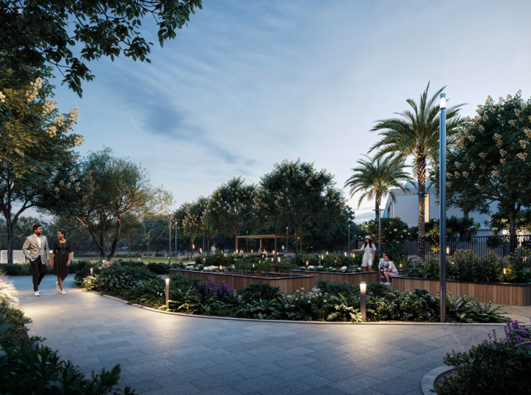 A well-lit pedestrian walkway in a lush green community garden at Greenspoint, Emaar South, with people enjoying an evening stroll.3 & 4 Bedroom Townhouses at Greenspoint, Emaar South