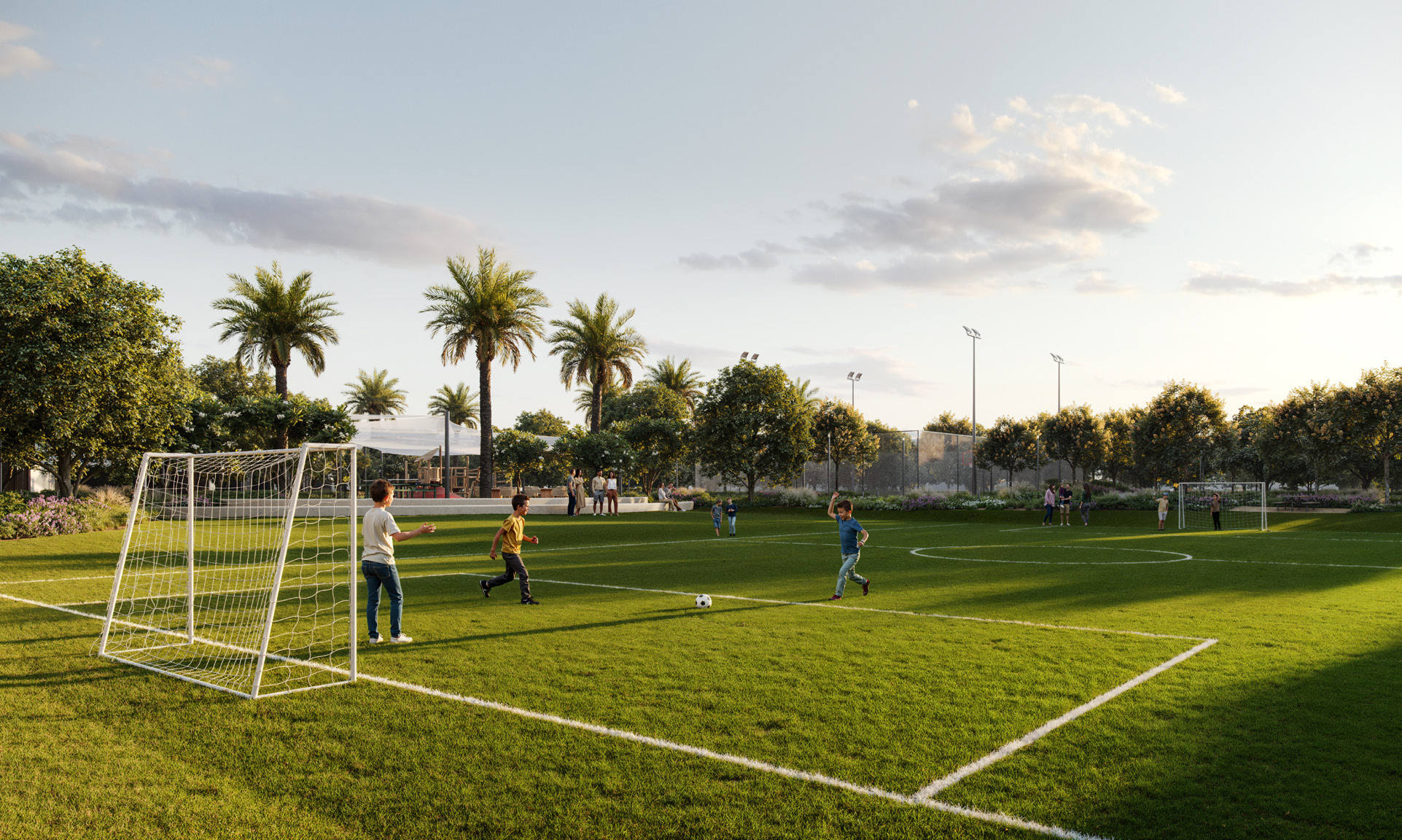 A lush green football field with children playing under the open sky at Greenspoint, Emaar South3 & 4 Bedroom Townhouses at Greenspoint, Emaar South.